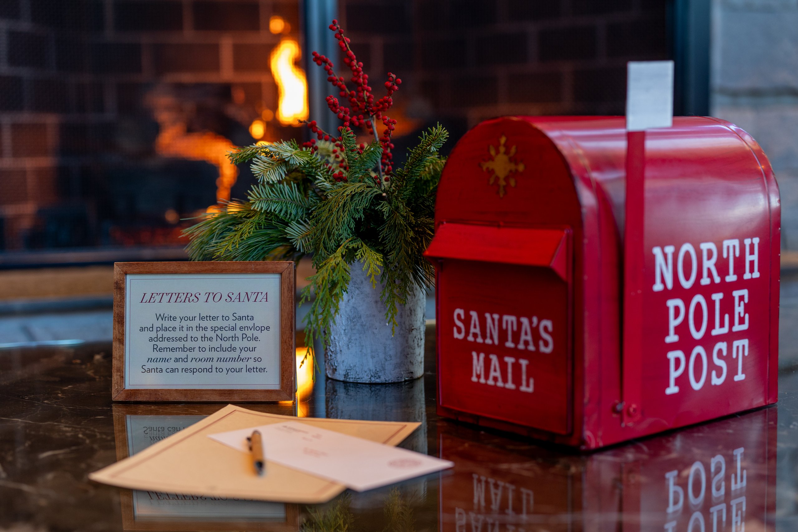 Letter to Santa on table with red north pole mailbox
