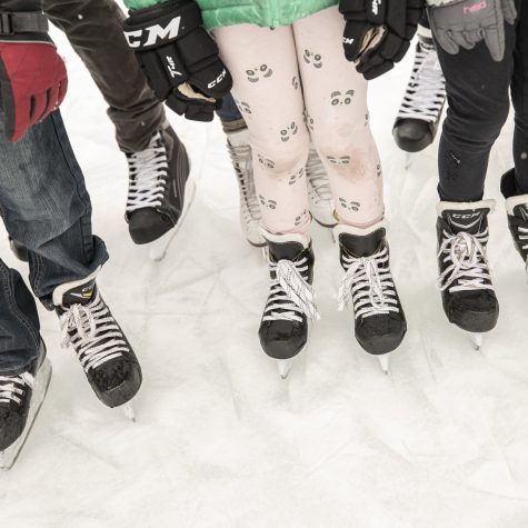 Close up of ice skates worn on ice.