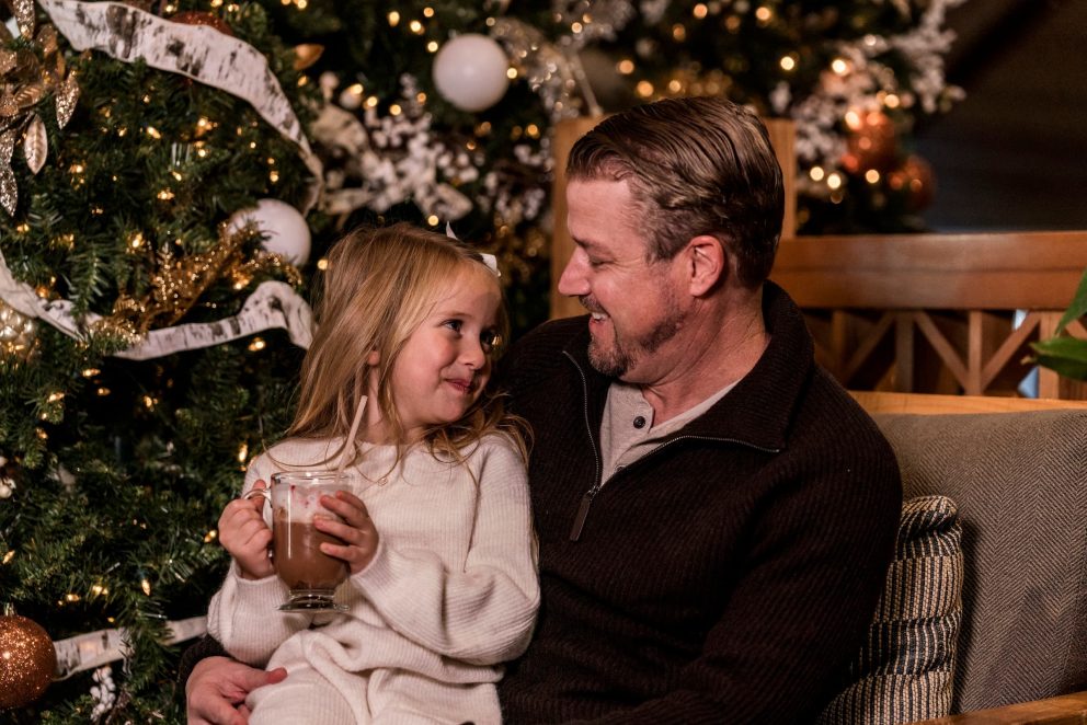 Father and daughter in front of Christmas tree
