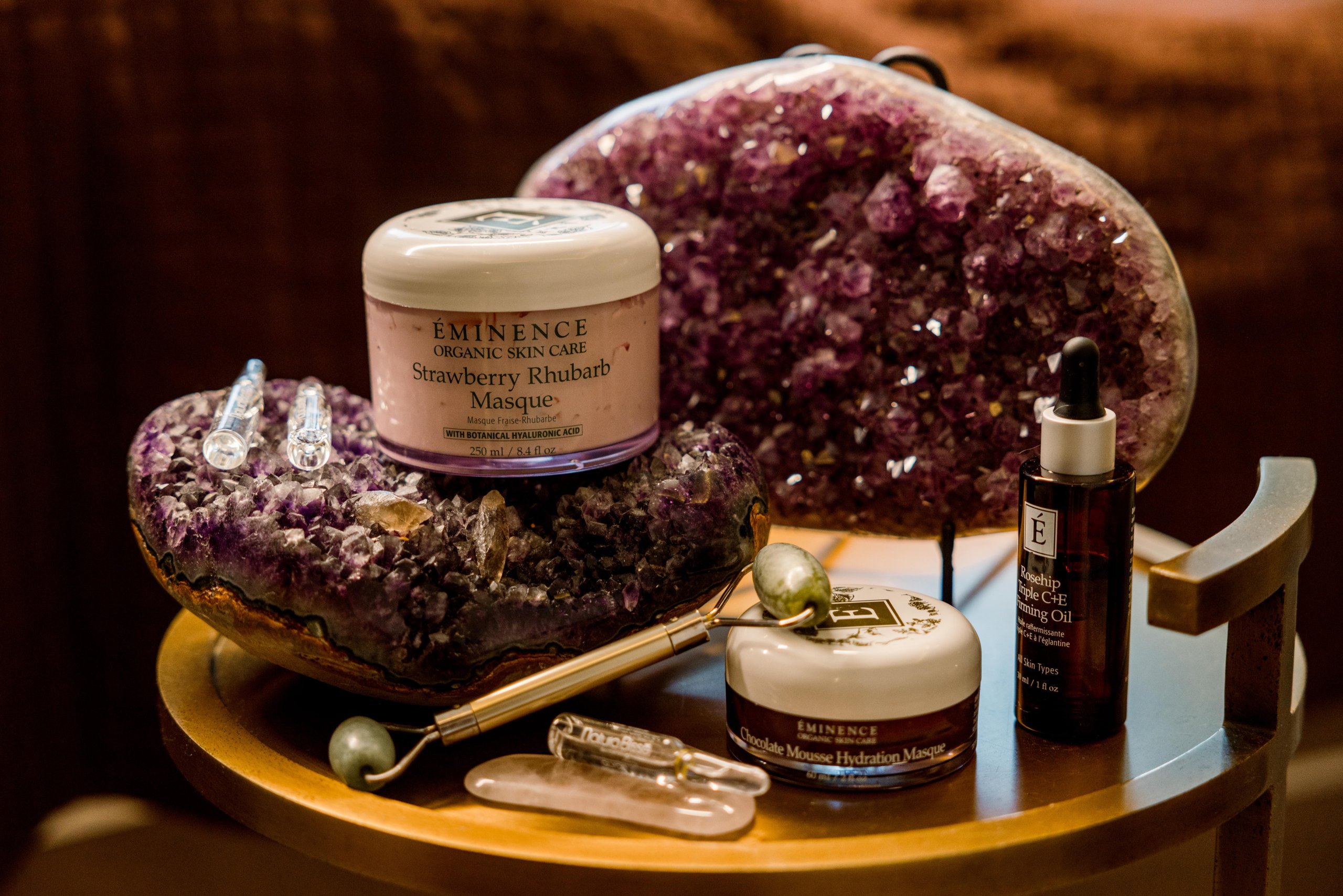 strawberry facial products on table with crystals and spa utensils